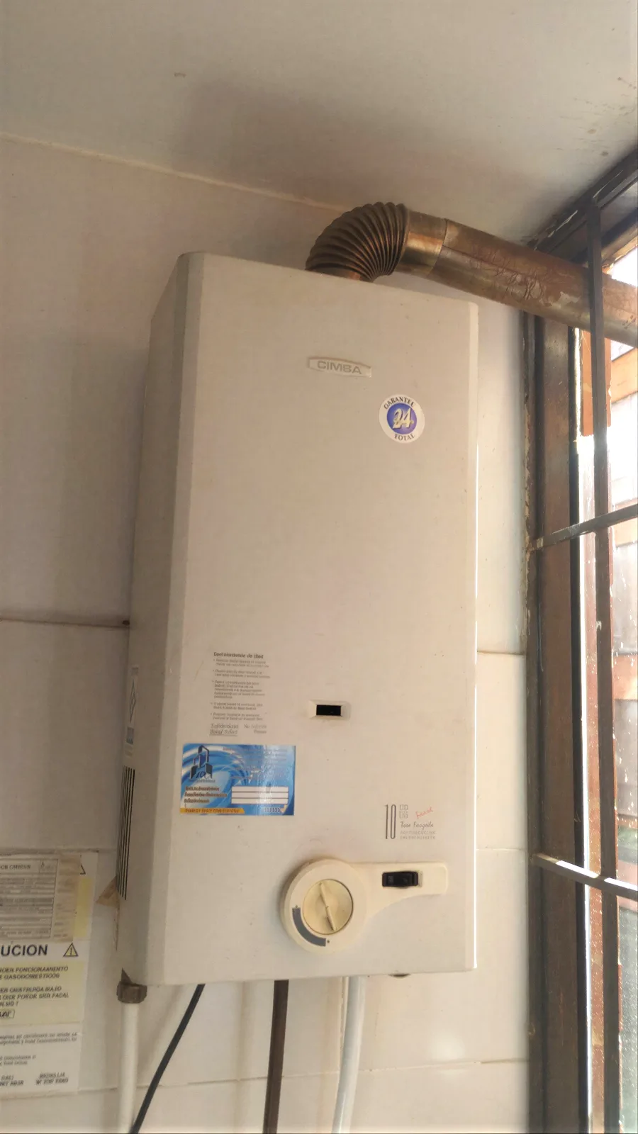 Calentador de paso a gas con ducto de evacuación de gases bien instalado en una vivienda de Medellín