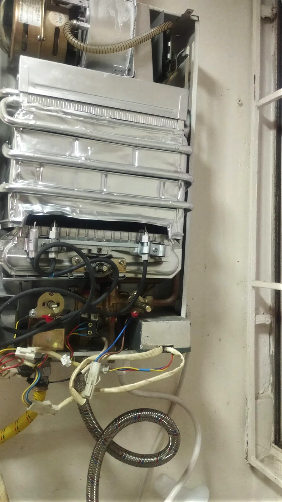 Reparación interna de un calentador de paso a gas con la carcasa retirada durante el diagnóstico
