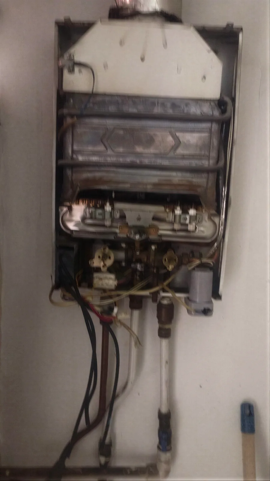 Revisión de quemadores y válvula de gas de un calentador de paso durante una visita de Servi Hogar