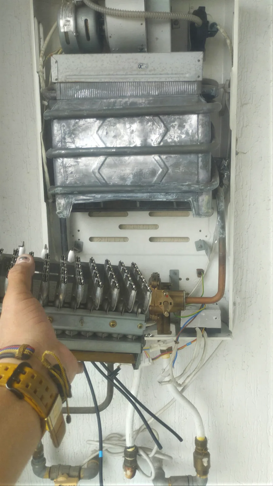 Técnico de Servi Hogar reparando por dentro un calentador de agua a gas a domicilio en Medellín